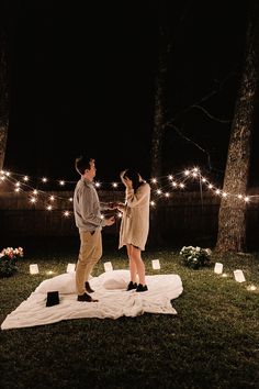 a man and woman standing on top of a blanket