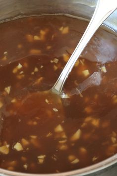 a pot full of soup with a spoon in it