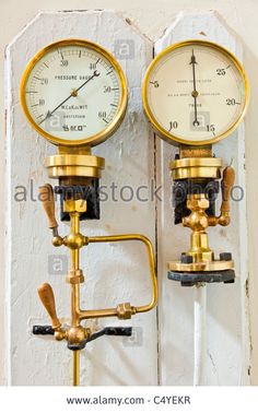 two gauges attached to the side of a wall with water pressure meters on it