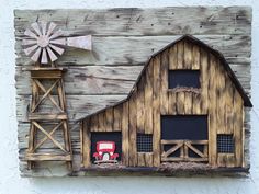 an old barn with a windmill on the side and a red truck in the window