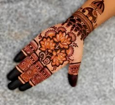 a woman's hand with henna tattoos on it