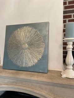 a painting on a mantle next to a lamp