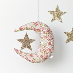 two stars and a crescent hanging from the ceiling next to each other with flowers on them