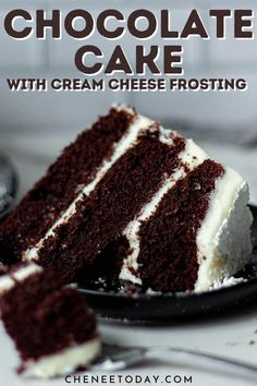 a slice of chocolate cake with cream cheese frosting on a black plate next to a fork