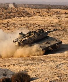 an army tank driving through the desert