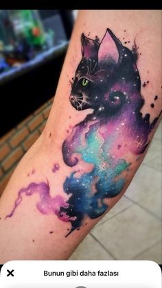 a cat tattoo on the arm with watercolor paint and stars in it's eyes