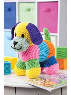 a crocheted dog sitting on top of a table next to blocks and toys