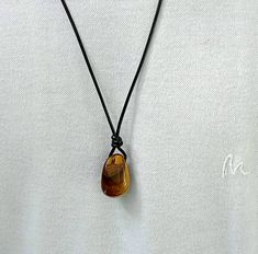 "Mens necklace, Tiger eye necklace, stone pendant, unisex necklace, energy stone necklace, tiger eye stone necklace, birthstone necklace,  necklace length 15\"-30\" adjustable cord   Stone size -19 x 29mm( approx.)   leather cord -2mm *Tiger Eye The zodiac stone for June, tiger's eye is in the quartz family. .it is, in fact, a good luck bringing stone that protects the wearing from evil thoughts and all ill wishes of enemies.it also possesses many healing properties. .Tiger Eye reduces the chronic pains, improves the strength of spines, and detoxifies the body. .It boosts up your confidence level. .It gets you mental clarity and decidedness. As the jewellery is made by hand, each item is unique and may vary slightly in size and colour to those photographed here. Please be aware that it is Tiger Eye Necklace Men, Tigereye Necklace, Birthday Gift For Husband, Evil Thoughts, Tiger Eye Necklace, Confidence Level, Zodiac Stones, Tiger Eye Jewelry, Necklace Birthstone