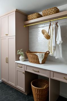 a laundry room with baskets and towels hanging on the wall