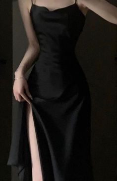 a woman in a black dress holding her hand out