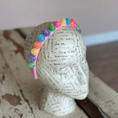 a white mannequin head with colorful beads on it