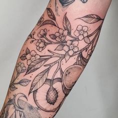 a tattoo on the arm of a person with flowers and fruit in it's branches