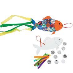 an assortment of craft items including plastic fish, scissors and paper streamers on a white background