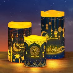 three lamps are sitting on a table in front of a night sky with stars and clouds