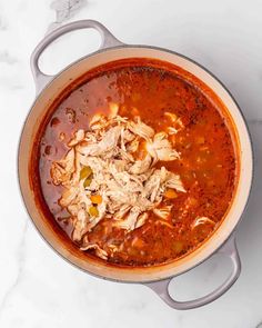 a pot of chicken tortilla soup on a marble countertop