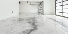 an empty garage with white walls and marble floors