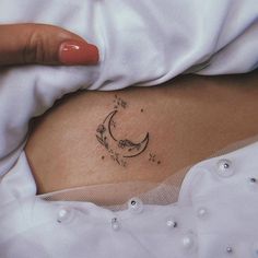 a woman's stomach with a small tattoo on her belly and flowers growing out of it