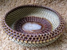 a brown and white bowl sitting on top of a carpet