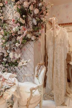 a room filled with lots of white furniture and flowers on the wall next to a chair