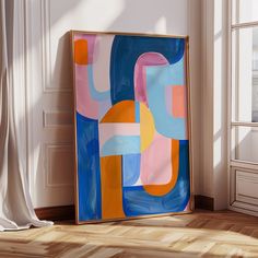 an abstract painting is on display in the corner of a room next to a window