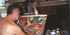 a man is painting on an easel in his living room