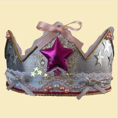 a silver and pink crown with a star on it