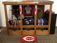 the reds locker is made out of wood and has baseball jerseys on display in it