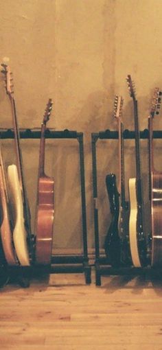 several guitars lined up against a wall