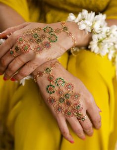 two hands with hendi designs on them and flowers in the middle one is yellow