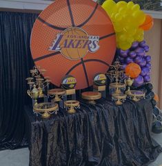 a table topped with trophies and balloons next to a basketball