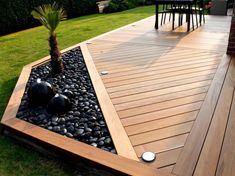 a wooden deck surrounded by rocks and plants