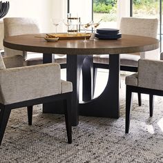 a dining table with chairs around it and plates on the table in front of them