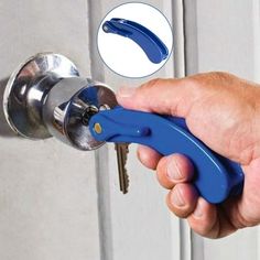 a hand holding a blue handled wrench in front of a door handle with a key on it