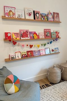 the children's books are lined up on the wall above the chair and table