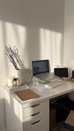 a white desk with a laptop computer on top of it