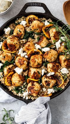 a skillet filled with chicken and vegetables on top of rice next to a wooden spoon