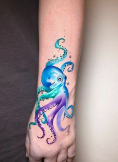 an octopus tattoo on the left wrist and right hand is painted with watercolors