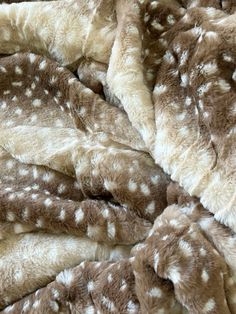 the blanket is brown and white with deer spots on it's fur, as well as other things