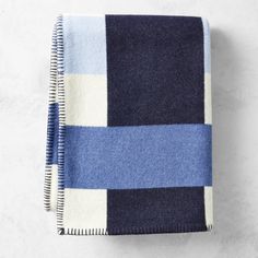 a blue and white checkered blanket folded on top of a table next to a pen