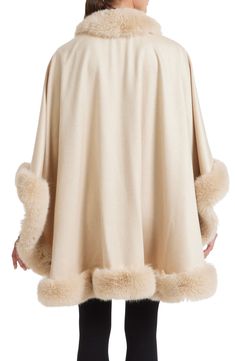 Take the avenue in the refined style of this voluminous cashmere cape finished perfectly with plush faux fur. 32" length (size O/S) Shawl collar Three-quarter sleeves 100% cashmere with 80% polyester, 20% acrylic faux fur Dry clean Made in the USA of imported fabric Elegant Beige Wool Cape, Luxury Winter Poncho, Elegant Fur Cape Coat With Faux Fur Trim, Elegant Cape Fur Coat With Faux Fur Trim, Elegant Fur Coat With Faux Fur Trim Cape, Elegant Faux Fur Cape, Elegant Beige Cape Poncho, Elegant Faux Fur Cape With Lining, Elegant Faux Fur Winter Cape