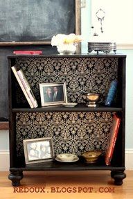 a book shelf with pictures and books on it in front of a chalkboard wall