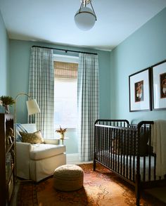 a baby's room with blue walls and curtains