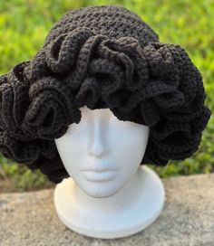 a white mannequin head wearing a black crochet wig