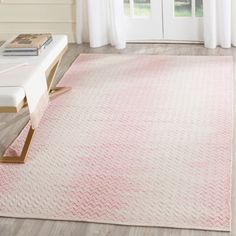 a pink and white rug in a living room