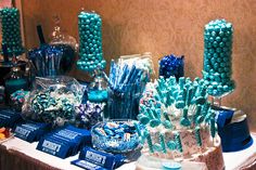 a table topped with lots of candy covered in blue and white frosted candies