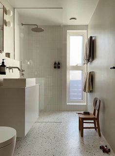 a bathroom with a toilet, sink and window