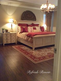 a bedroom with a bed, dressers and chandelier on the wall in it