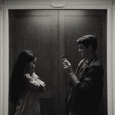 a man and woman standing in front of a door