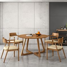 a wooden table with chairs around it in front of a gray wall and white tile floor