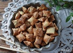 a bowl filled with food on top of a doily next to a wooden spoon